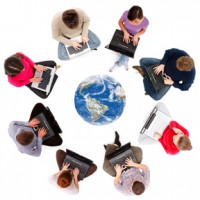 students on laptops sitting in circle around globe